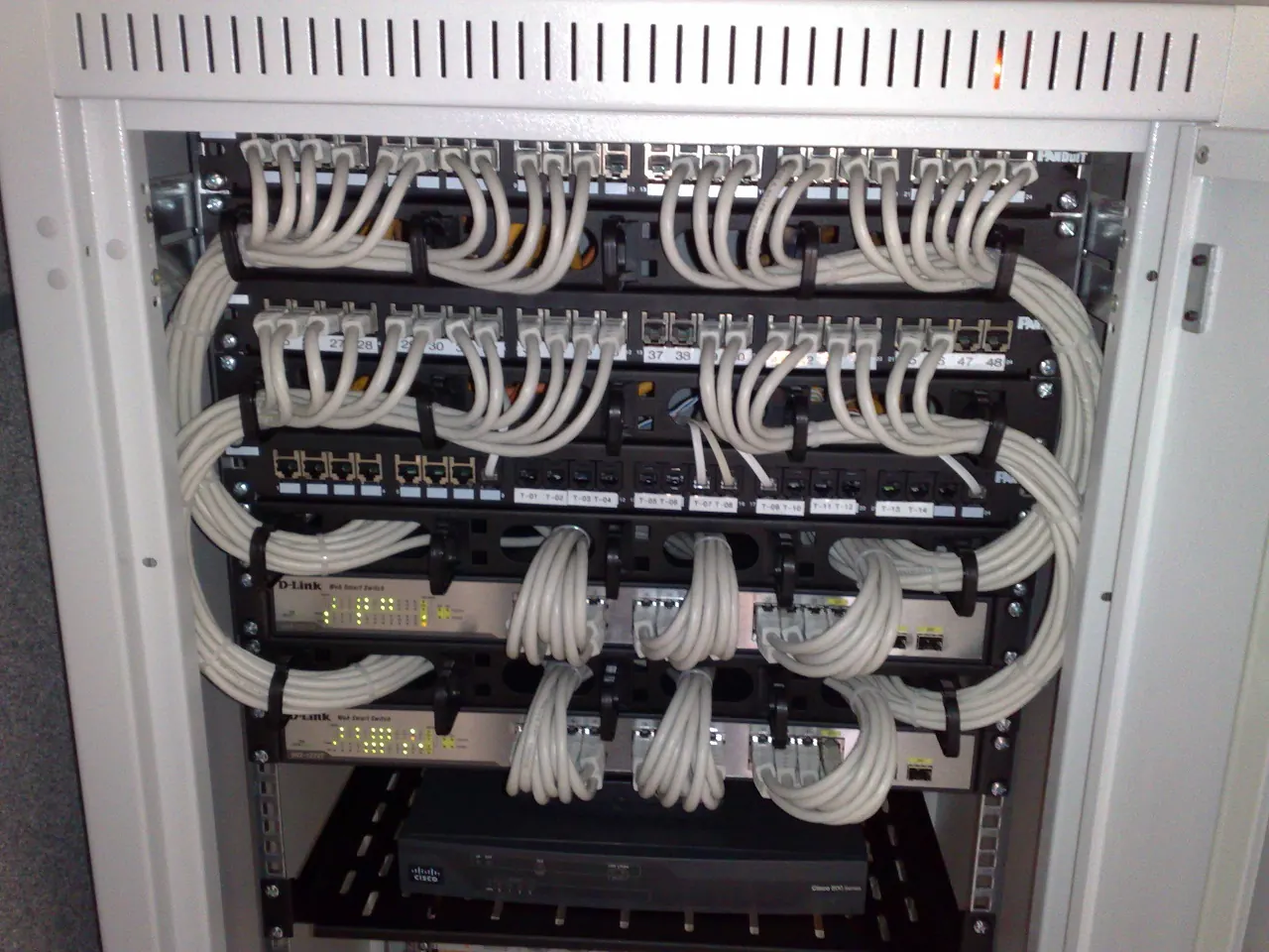 Rack-mounted network switches and patch panels, cabled neatly.